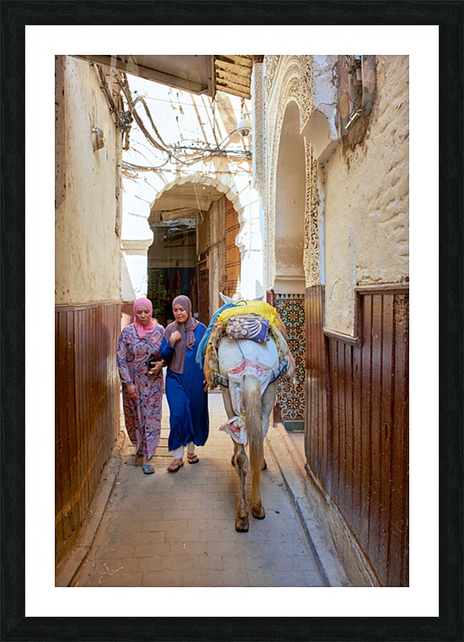Women walking with donkey in narrow alley of Fez Medina Picture Frame print