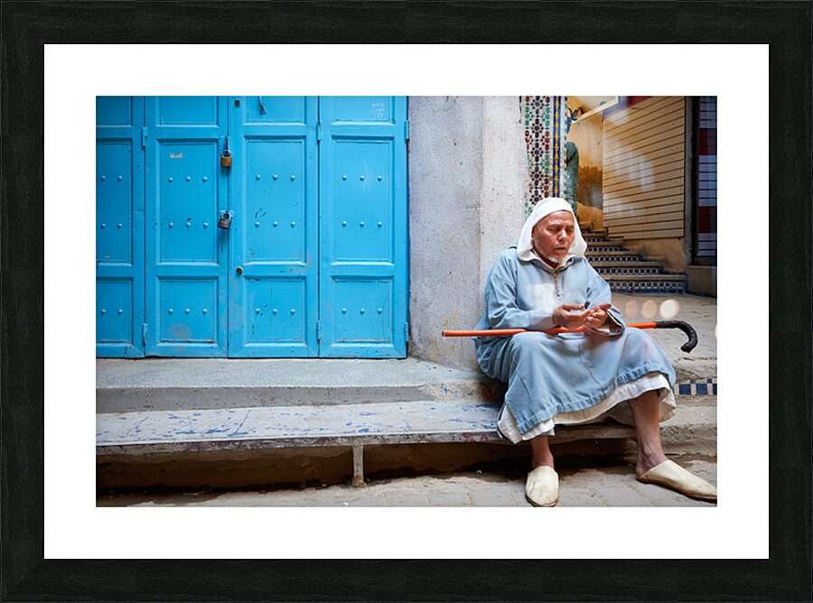 Portrait of a beggar sitting by a blue door in Fez Morocco Picture Frame print