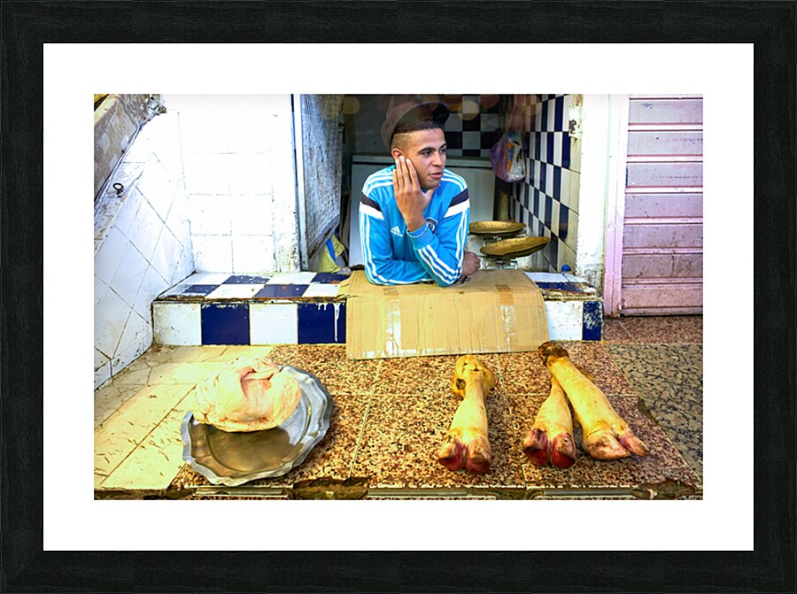 Butcher in Meknes souk interacts with customers during market ho Picture Frame print