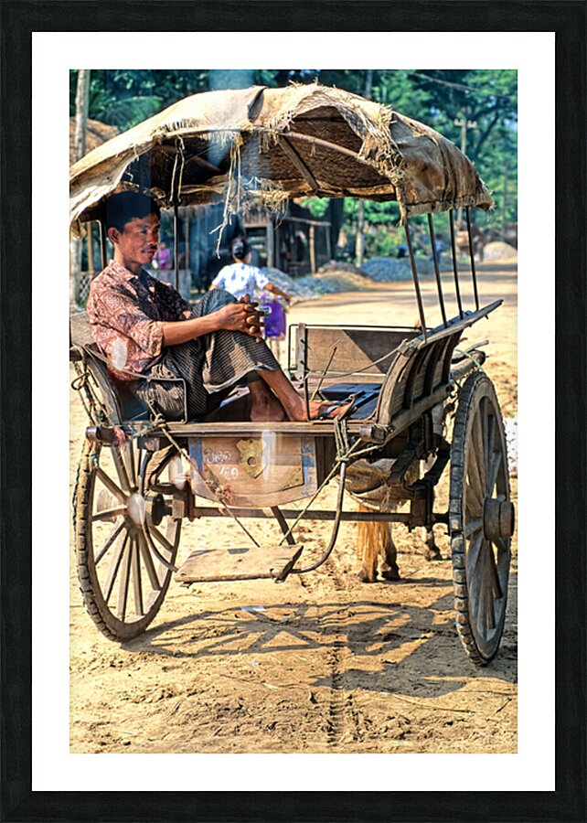 Man rests on cart in Myanmar during warm daytime Picture Frame print