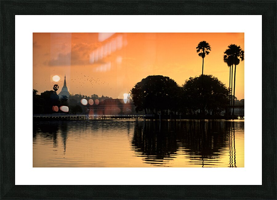 Sunset over the water in Yangon with palm trees and buildings Picture Frame print