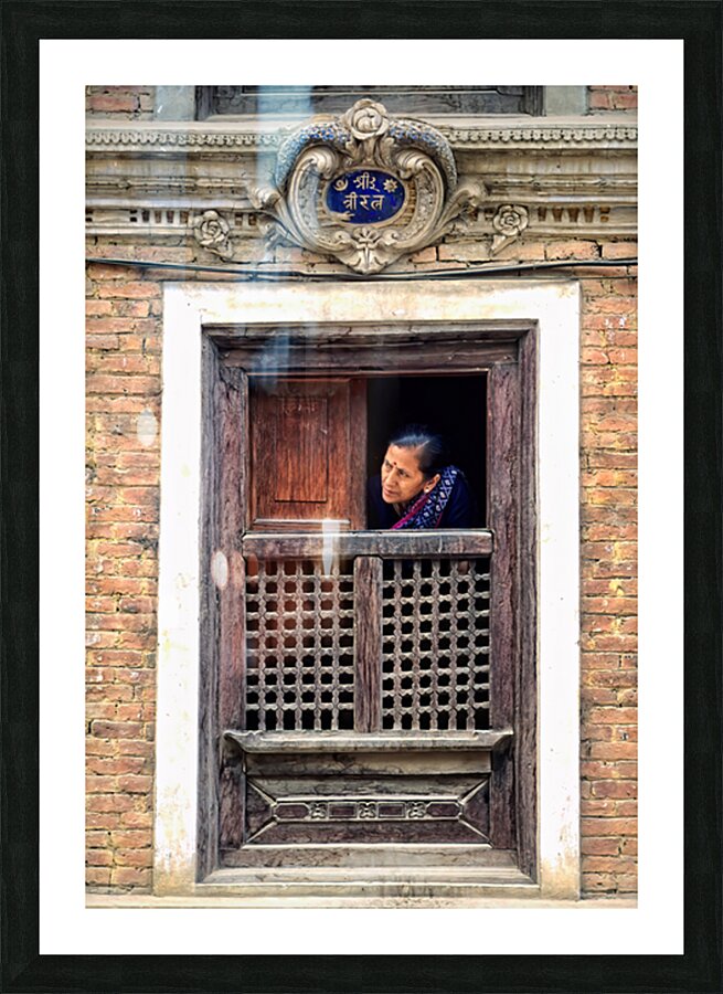 Woman in Kathmandu looks out from window in old building Picture Frame print
