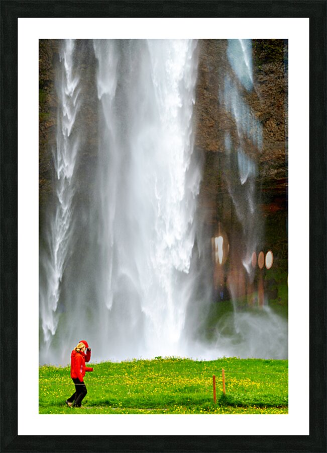 Woman walks near Seljalandsfoss waterfall in Iceland Picture Frame print