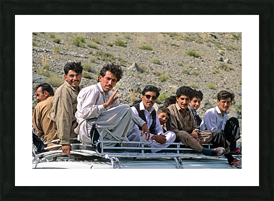 Group traveling on top of a van in Pakistans mountains Picture Frame print