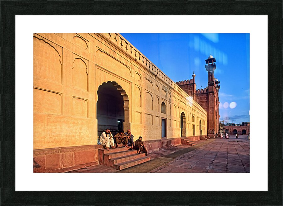 Visitors rest by Badshahi Mosque during sunset in Lahore Picture Frame print