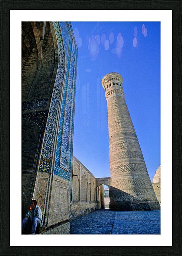 People rest near the tall minaret in Khiva Uzbekistan Picture Frame print