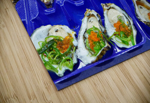 Fresh oysters with garnishes in blue trays. Marco Brivio puzzle