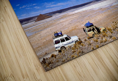 Vehicles traverse a vast arid salt flat landscape. Marco Brivio puzzle