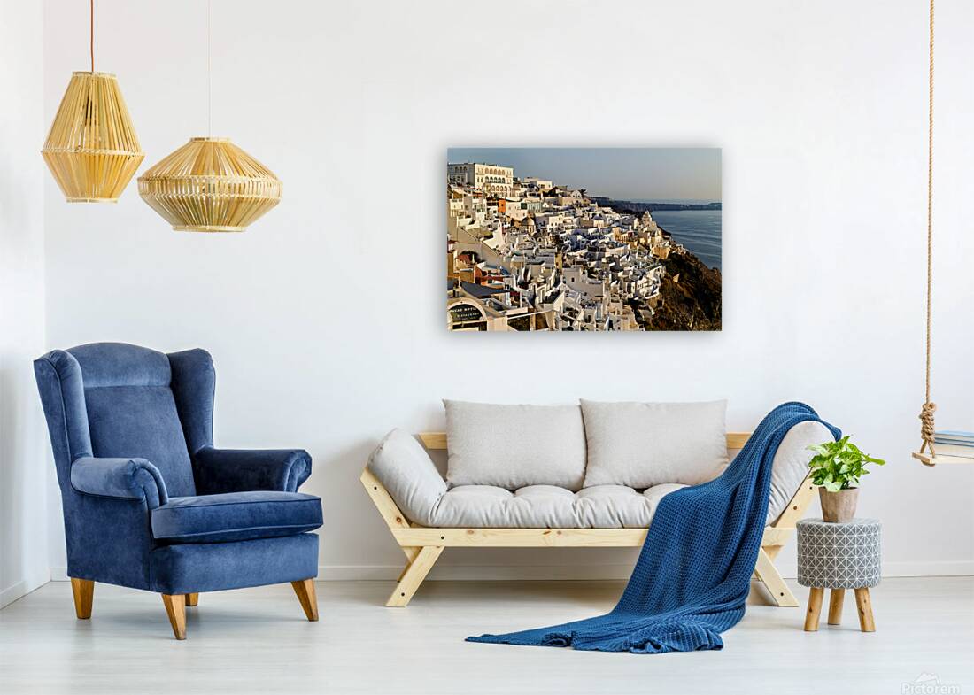 Santorinis white buildings cascade down cliff to the sea. Reproduction