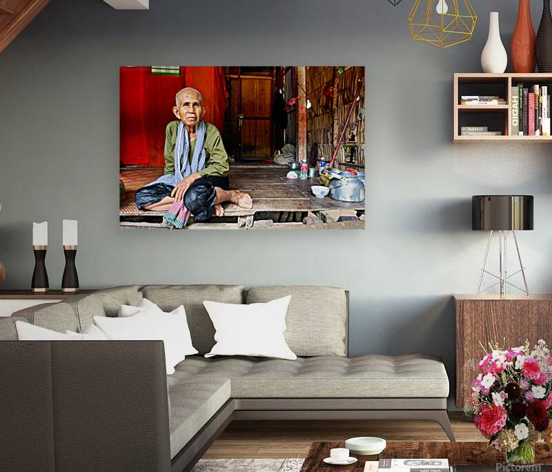 Elderly person sitting on floor in rustic dwelling. Reproduction