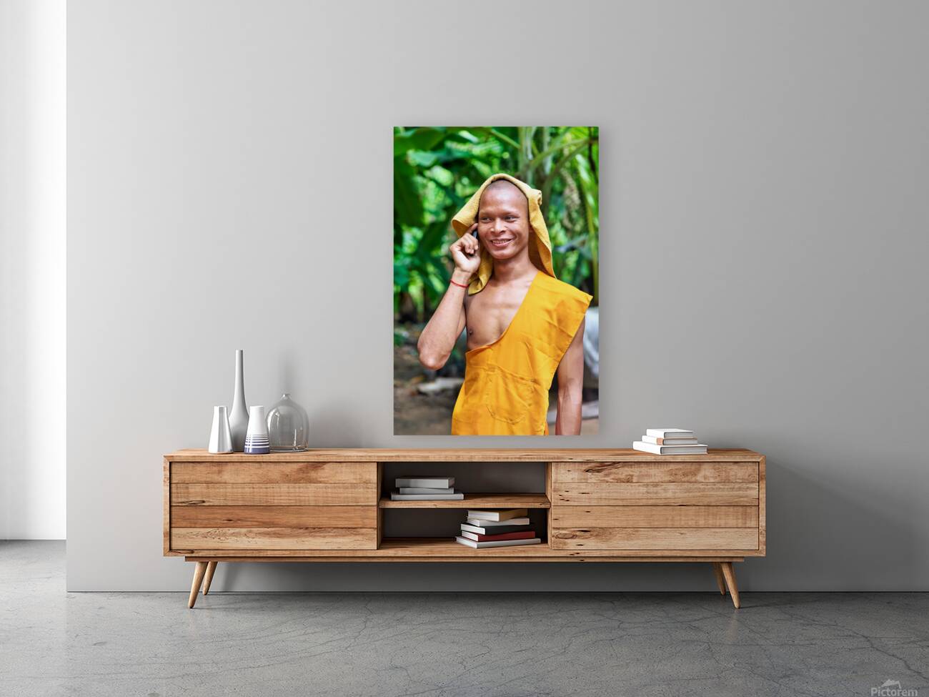 Smiling monk talks on phone with towel on head. Reproduction