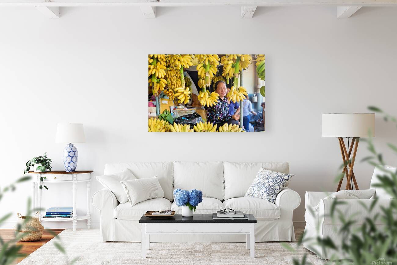 Market vendor surrounded by abundant yellow bananas. Reproduction