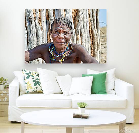 Old woman of Zemba Bantu ethnic group sits near wooden wall in N Reproduction