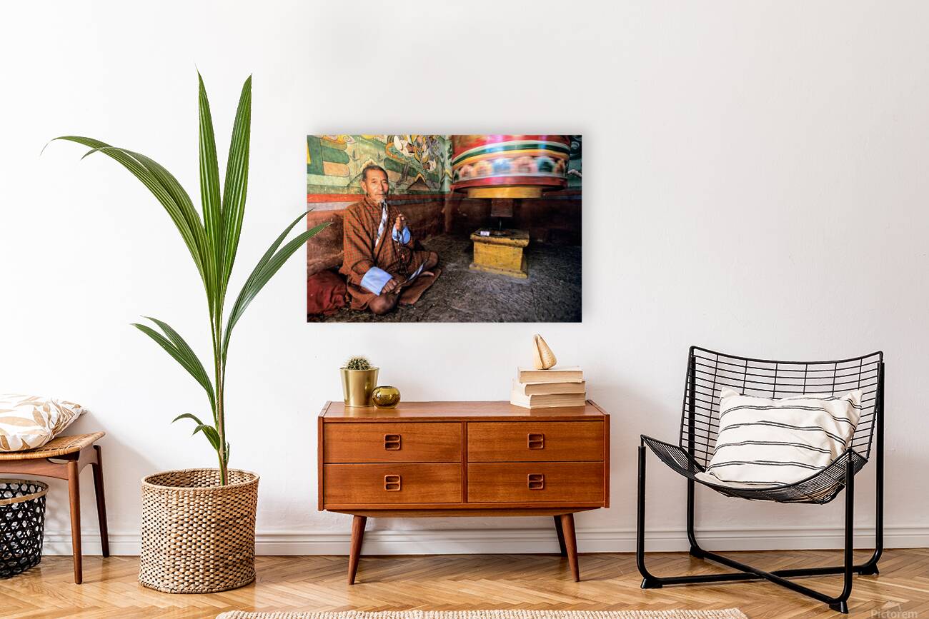 Bhutanese man with prayer beads and spinning prayer wheel. Reproduction