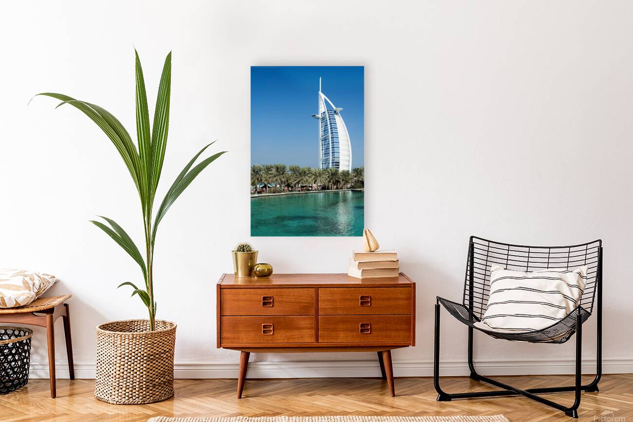 Burj Al Arab hotel stands tall by the water with palm trees Reproduction
