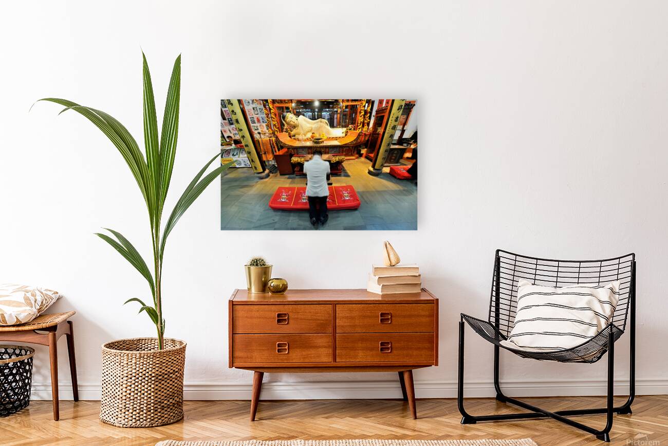 Worshipper kneels before Buddha statue in Shanghai temple Reproduction