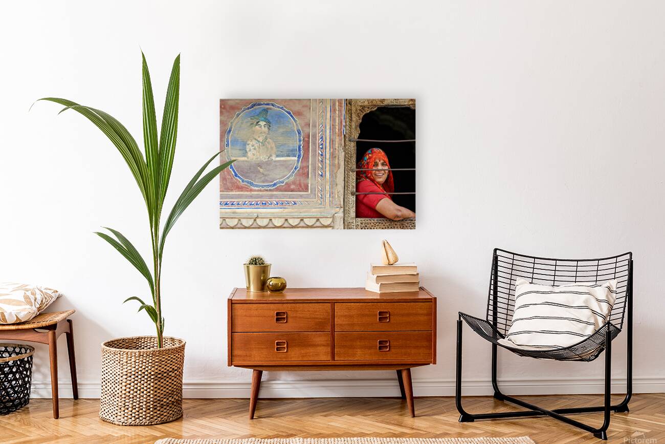 Woman smiles while looking out of a window in Mandawa Rajasthan Reproduction