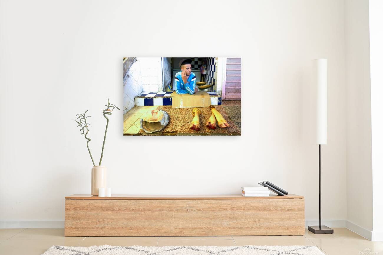 Butcher in Meknes souk interacts with customers during market ho Reproduction