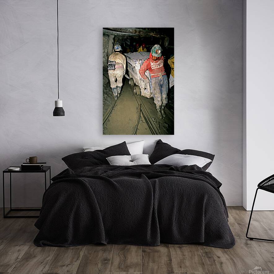 Miners pushing a loaded cart through a muddy underground mine. Reproduction