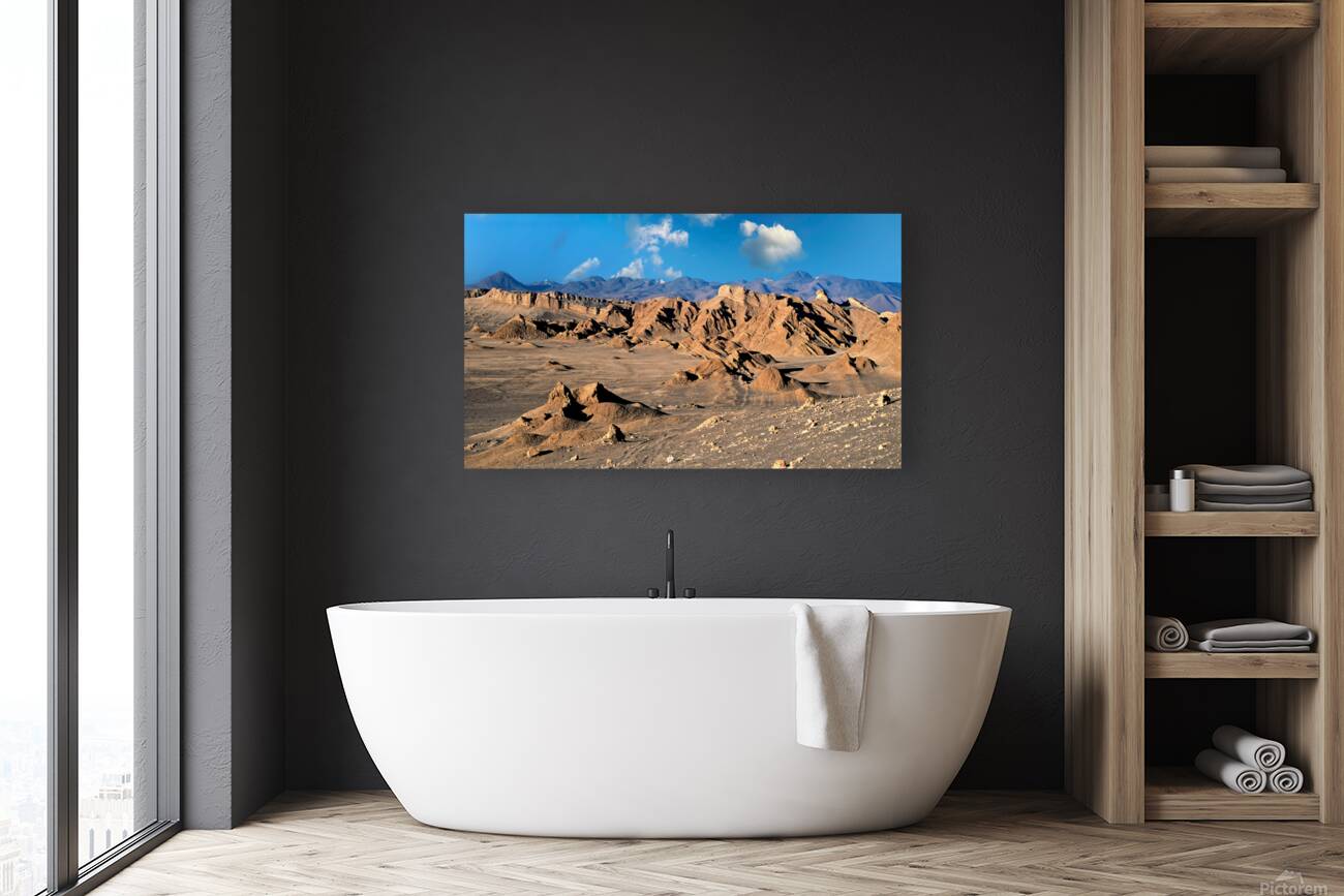 Rugged desert mountains under a clear blue sky with clouds. Reproduction