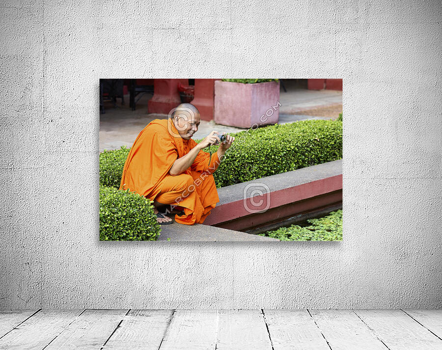 A buddhist monk taking a picture at the National Museum of Cambodia in Phnom Penh Wall Preview