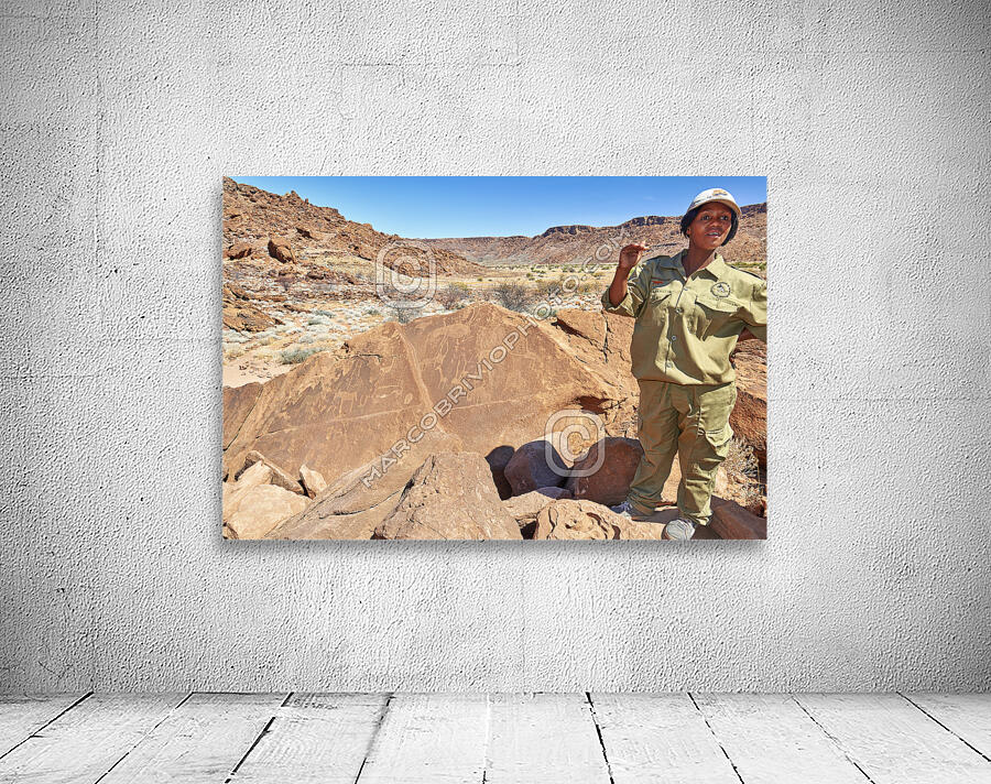 Namibia. A guide shows prehistoric rock engravings in Twyfelfontein archaeological site Wall Preview