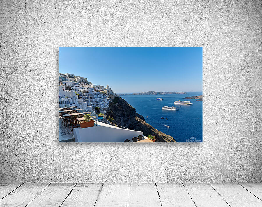 Santorinis white village blue caldera and cruise ships. Wall Preview