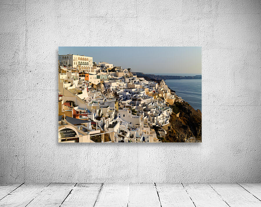 Santorinis white buildings cascade down cliff to the sea. Wall Preview