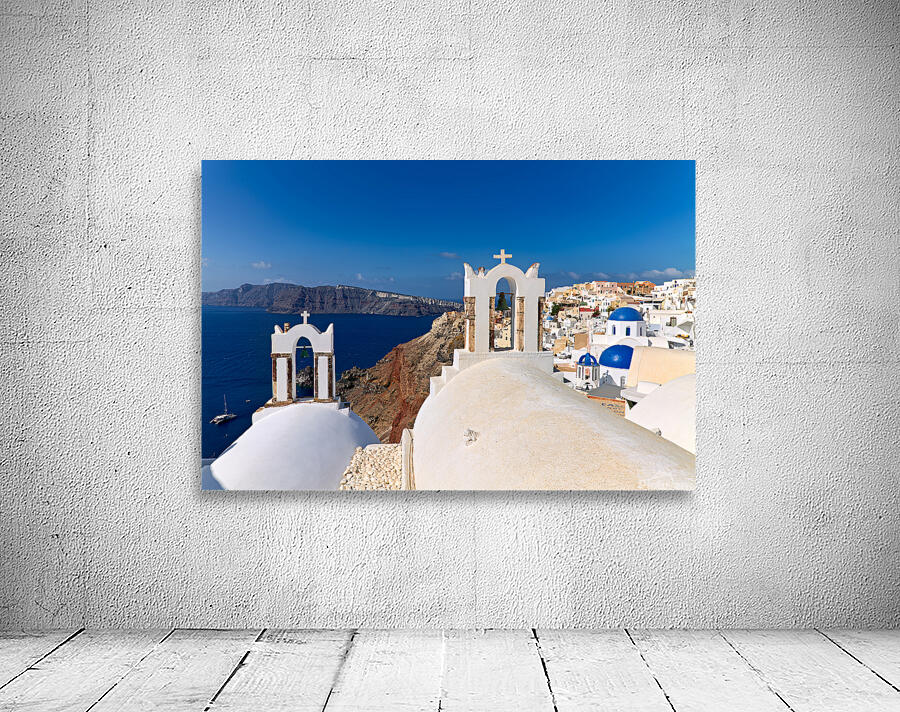 Santorinis iconic white churches blue domes and caldera view. Wall Preview