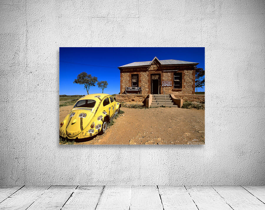 A painted yellow Beetle outside a rural stone gallery. Wall Preview