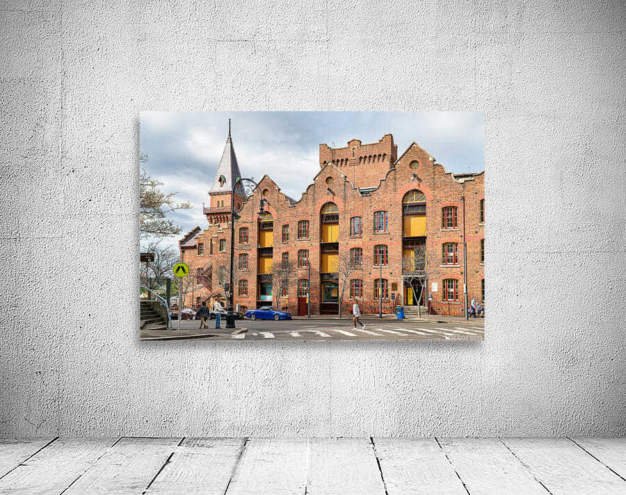 Historic brick building with a tower and people walking. Wall Preview