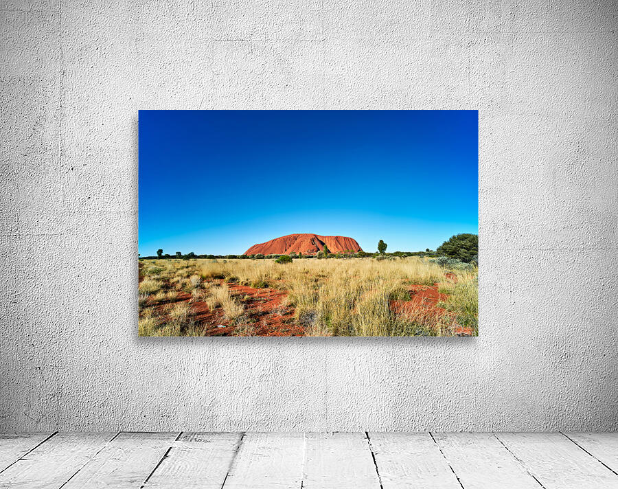 Uluru Australias iconic sandstone monolith under a clear blue Wall Preview