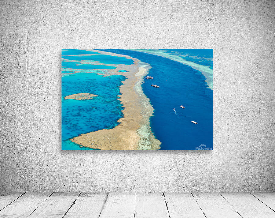 Aerial view of coral reefs and boats in turquoise ocean. Wall Preview