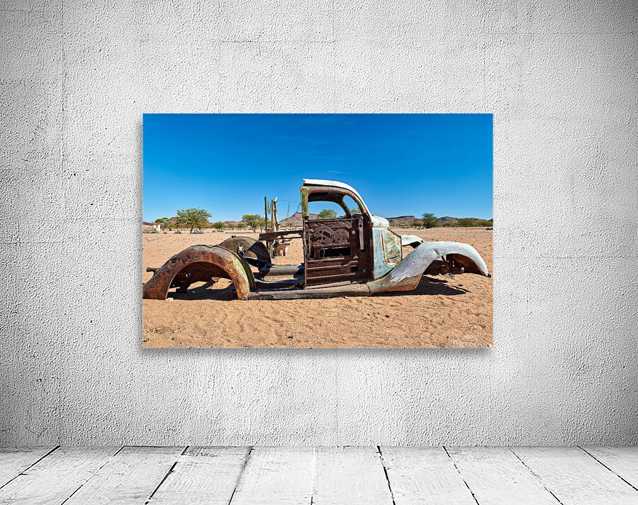 Classic car wreck rests in the Namib desert under a clear sky Wall Preview