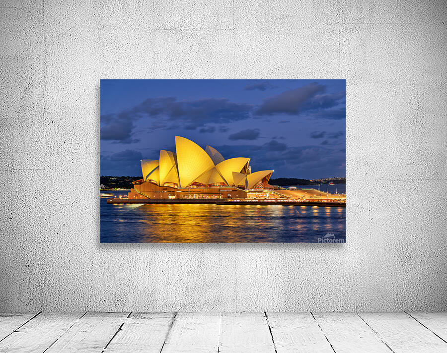 Sydney Opera House illuminated at dusk with harbor lights. Wall Preview