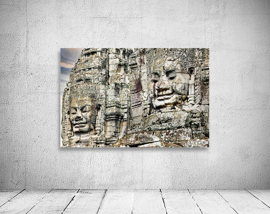 Serene stone faces adorn ancient Cambodian temple. Wall Preview