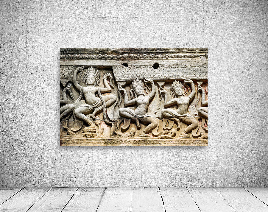 Ancient stone carvings of dancing Apsaras on a temple wall. Wall Preview