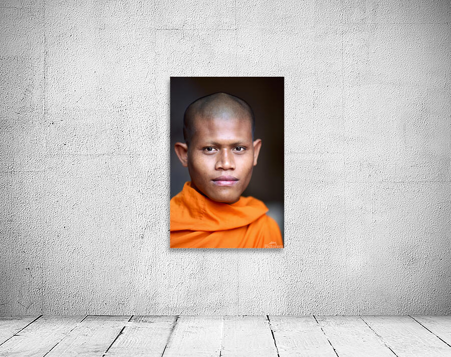 Young Buddhist monk in orange robe close up portrait. Wall Preview