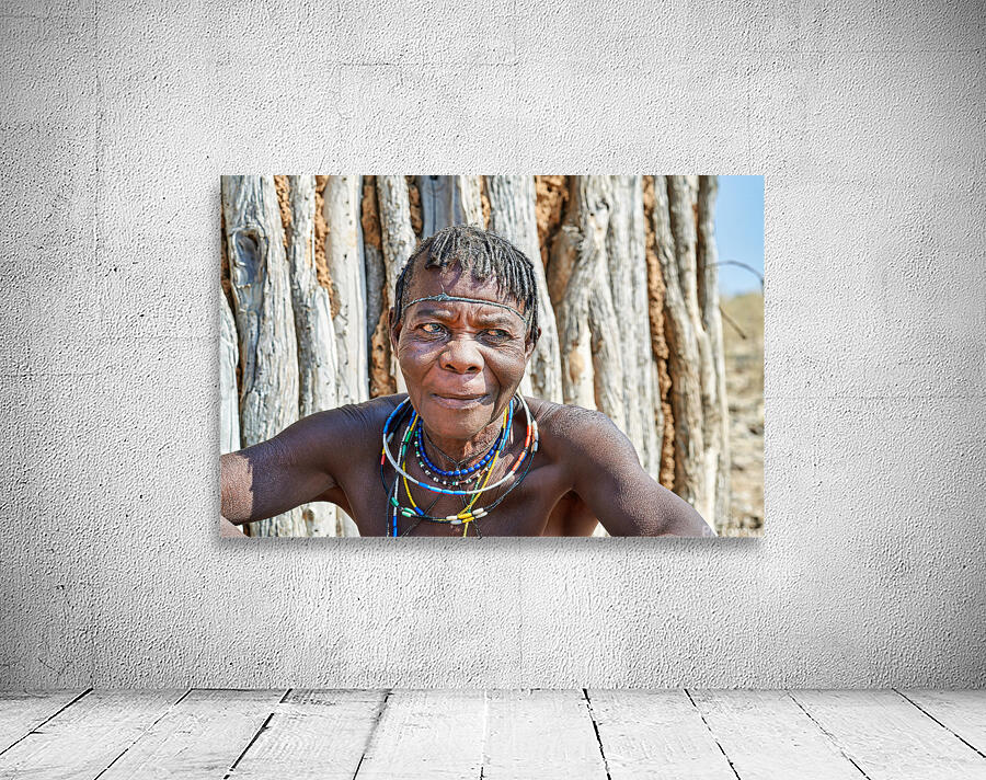 Old woman of Zemba Bantu ethnic group sits near wooden wall in N Wall Preview