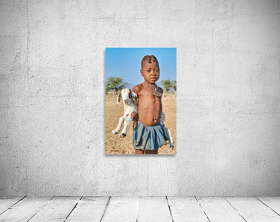Himba child holding a goat in Kunene Region of Namibia Wall Preview