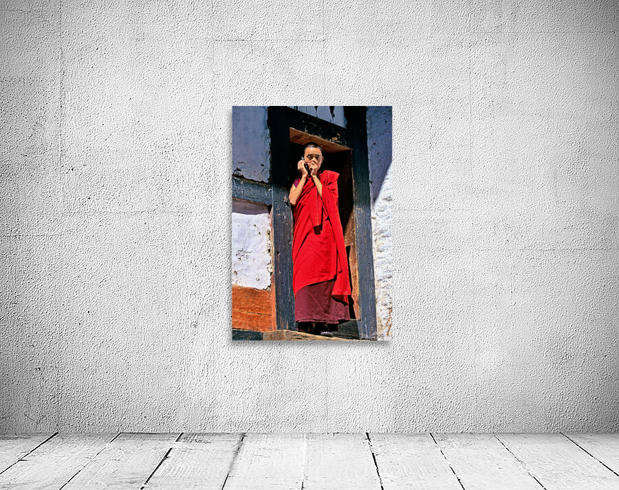 Monk in red robes on cell phone. Wall Preview
