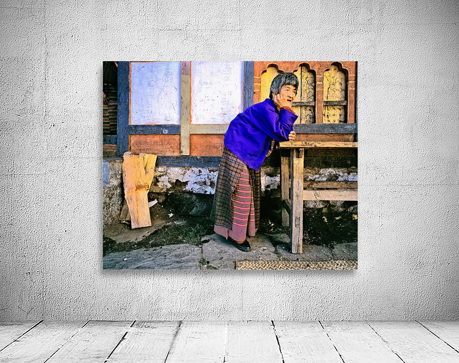 Smiling elderly woman in traditional dress leaning on wooden tab Wall Preview