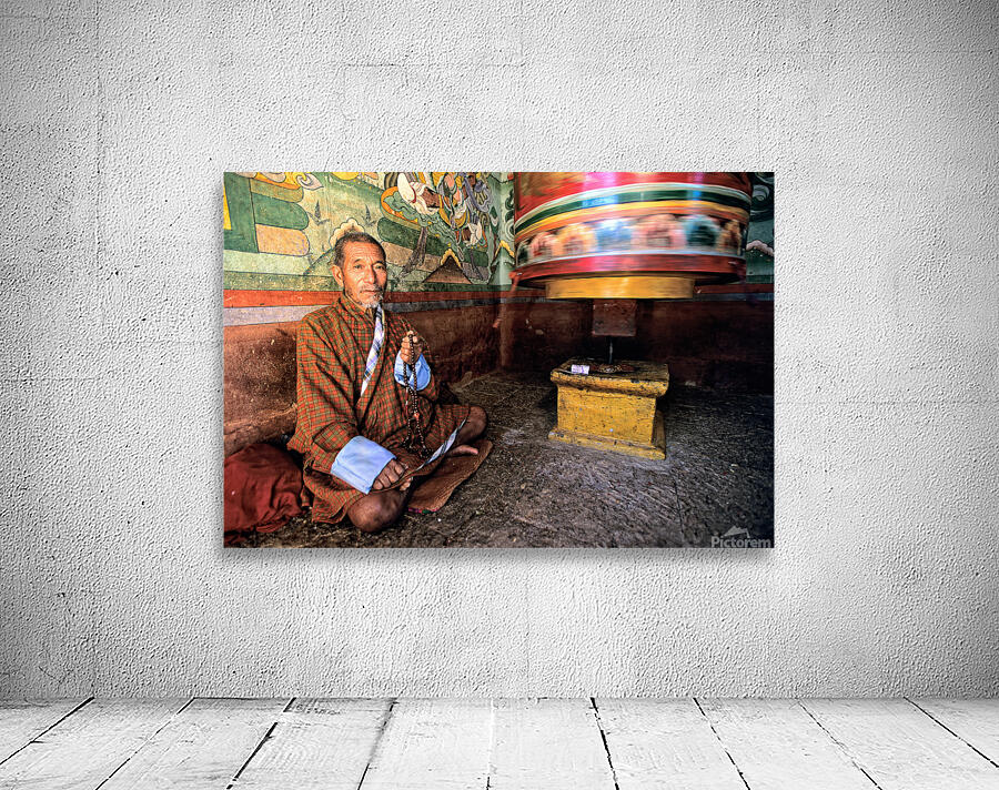 Bhutanese man with prayer beads and spinning prayer wheel. Wall Preview