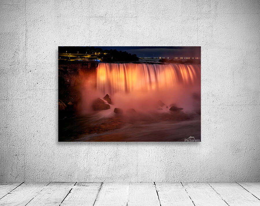 Niagara Falls illuminated orange at night. Wall Preview