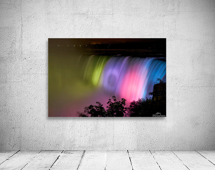 Niagara Falls illuminated with vibrant colors at night. Wall Preview