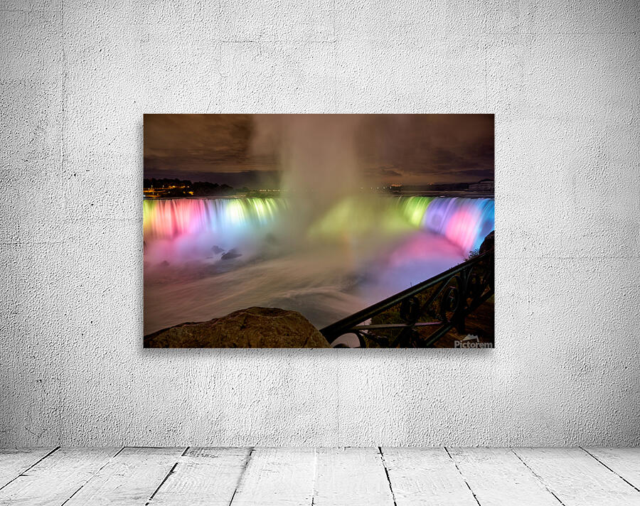 Niagara Falls illuminated at night with colorful lights. Wall Preview