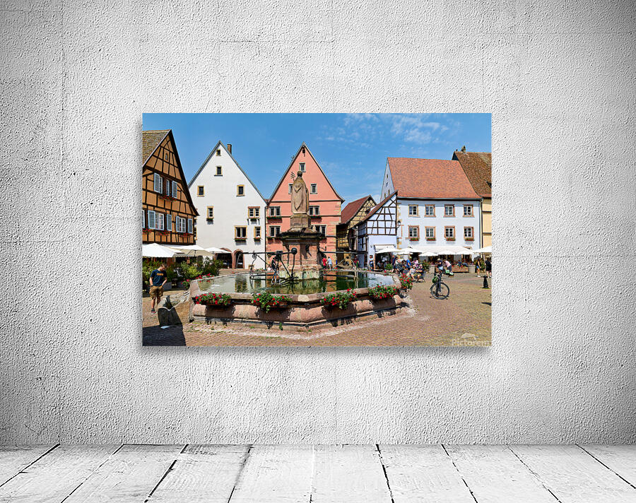 Visitors enjoy Saint Leon square in Eguisheim Alsace on a sunny Wall Preview
