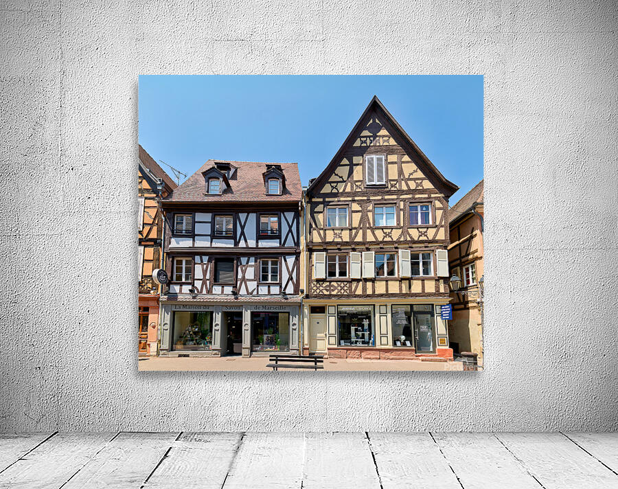 Visitors explore timber framed houses in Colmar Alsace on a sun Wall Preview