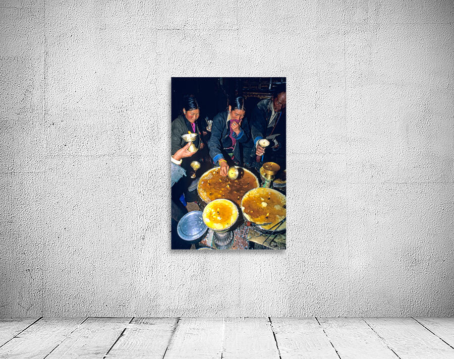 Lighting butter lamps during a ceremony in Tibet Wall Preview