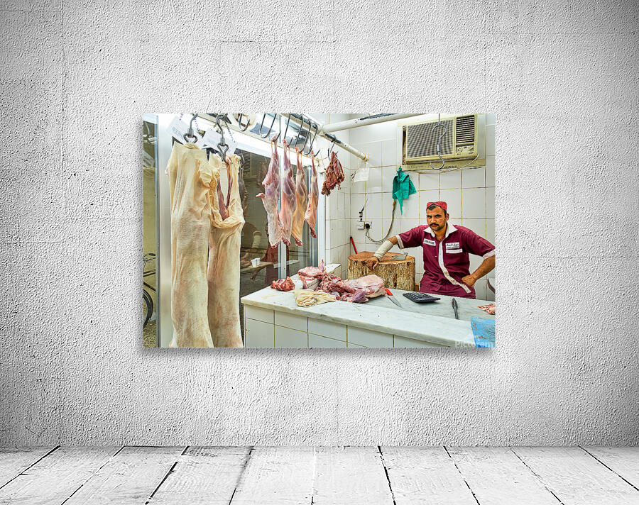 Butcher works in meat market in Dubai with hanging meat Wall Preview